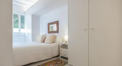 a white bedroom with a bed and a mirror at Stay U-nique Apartments Llibertat in Barcelona