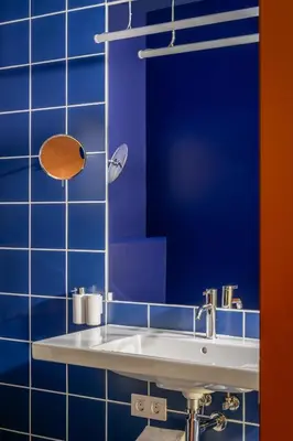 a bathroom with a white sink and blue tiles at BYPILLOW Flamant in Barcelona