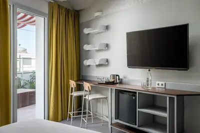 a hotel room with a desk with a flat screen tv at BYPILLOW Flamant in Barcelona
