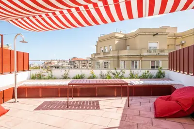 a patio with an umbrella on top of a building at BYPILLOW Flamant in Barcelona