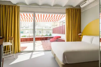 a bedroom with a bed and a large window at BYPILLOW Flamant in Barcelona