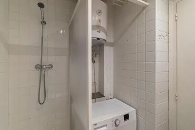 a white bathroom with a shower and a toilet at Stay U-nique Apartment Creu Coberta in Barcelona