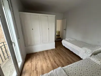 a bedroom with two beds and a large window at LEsglesia 1 in Arenys de Mar