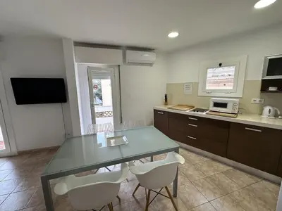 a kitchen with a glass table and white chairs at LEsglesia 1 in Arenys de Mar