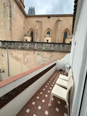 a balcony with two white chairs on a building at LEsglesia 1 in Arenys de Mar