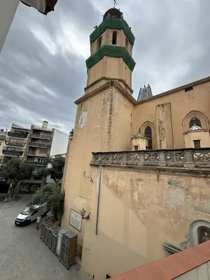 a building with a clock tower on top of it at LEsglesia 1 in Arenys de Mar
