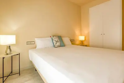 a bedroom with a large white bed and two lamps at Love in Cuba in Sitges