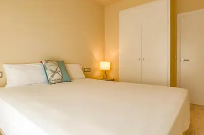 a bedroom with a large white bed and a lamp at Love in Cuba in Sitges