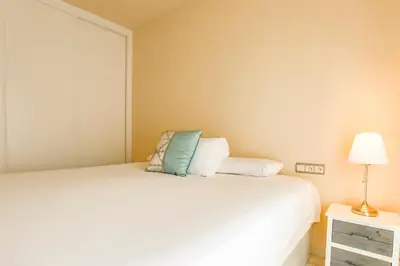 a bedroom with a white bed and a lamp at Love in Cuba in Sitges