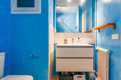 a blue bathroom with a sink and a toilet at Love in Cuba in Sitges