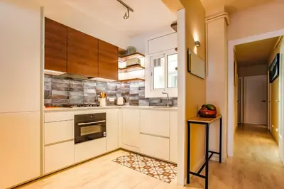 a kitchen with white counters and wooden cabinets at Love in Cuba in Sitges