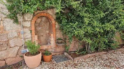 a stone wall with a brick arch and potted plants at Can Puig Barata, Aiguafreda in Aiguafreda