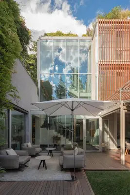 a glass house with a patio and an umbrella at ABaC H&R Barcelona Monument in Barcelona
