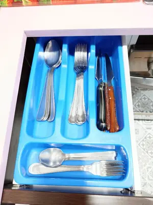 a blue tray with silver utensils in a drawer at Ca la Fiona in Monistrol
