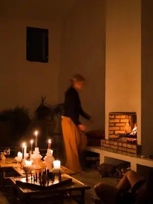 a woman standing in a living room with a fireplace at Soul Farm Mas els Igols in Torrellas de Foix