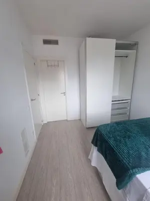 a bedroom with white walls and a bed and two closets at 1 Habitación Matrimonial Privada con baño incluido in Barcelona