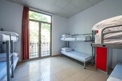 a room with several bunk beds and a window at Safestay Barcelona Passeig de Gràcia in Barcelona