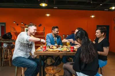 a group of people sitting around a table eating food at Safestay Barcelona Passeig de Gràcia in Barcelona