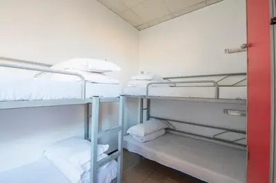 a room with three bunk beds with white towels at Safestay Barcelona Passeig de Gràcia in Barcelona