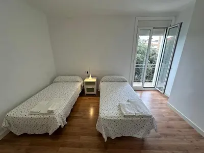 two beds in a room with a window at Esglesia 2 in Arenys de Mar