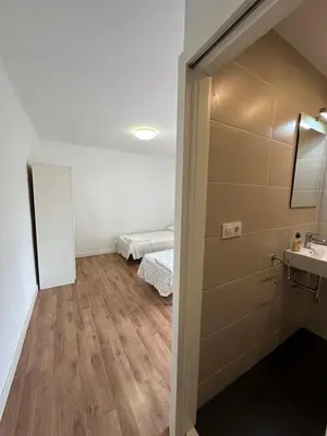 a room with two beds and a sink and a mirror at Esglesia 2 in Arenys de Mar