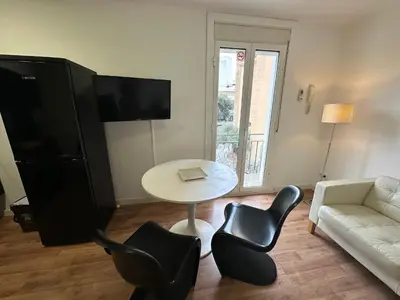 a living room with a white couch and a table and chairs at Esglesia 2 in Arenys de Mar