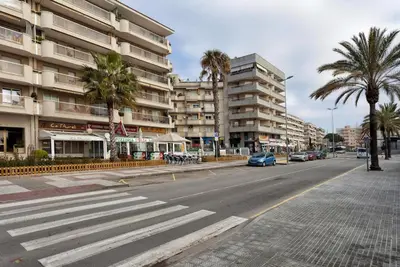an empty city street with palm trees and buildings at Perfect Apartment near the beach and Barcelona in Pineda de Mar
