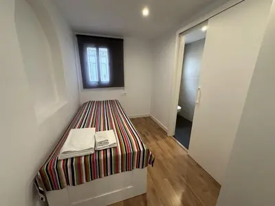 a small room with a bed and a window at L'Esglesia 3 in Arenys de Mar