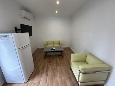 a room with a refrigerator and a table and a chair at L'Esglesia 3 in Arenys de Mar