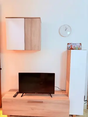 a flat screen tv sitting on top of a wooden table at Amazing and stylish flat for 4 people with breakfast included 2 blocks away from Poblenou beach in Barcelona