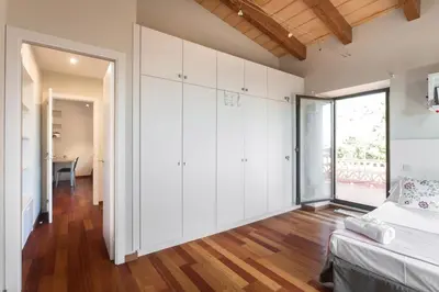 a bedroom with white cabinets and a large window at Mas Vives, exclusiva masía del siglo XV in Cabrils