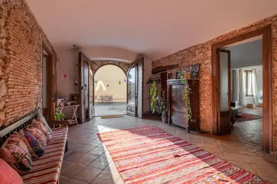 a living room with a couch and a brick wall at Mas Vives, exclusiva masía del siglo XV in Cabrils