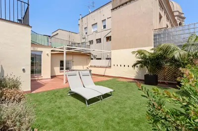 a white chair sitting on a lawn in a yard at Flateli Pelayo H7 in Barcelona