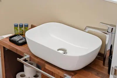 a white sink on a wooden counter in a bathroom at Flateli Pelayo H7 in Barcelona
