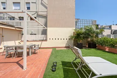 a patio with chairs and a table and grass at Flateli Pelayo H7 in Barcelona