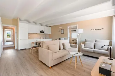 a living room with a couch and a kitchen at Flateli Pelayo H7 in Barcelona