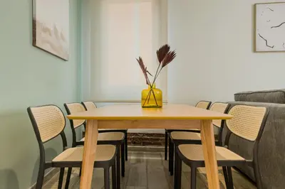 a dining room table with chairs and a vase on it at Novus Homes Barcelona Plaza España in Barcelona