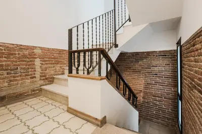 a stairway with a brick wall and a stair case at Novus Homes Barcelona Plaza España in Barcelona
