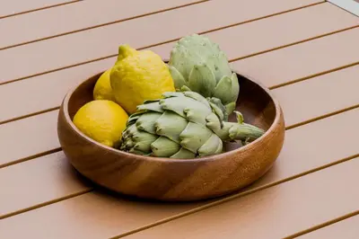 a wooden bowl of fruits and vegetables on a table at Novus Homes Barcelona Plaza España in Barcelona