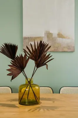 a vase with flowers in it on a table at Novus Homes Barcelona Plaza España in Barcelona