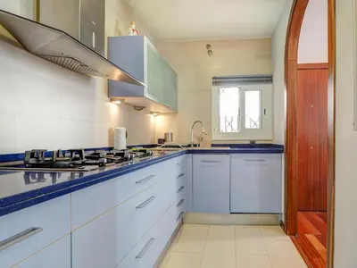 a kitchen with white cabinets and a stove at Ollie Apartment by Hello Homes Sitges in Sitges