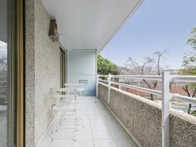 a balcony with a desk and a chair on it at Winahost Barcelona Pedralbes in Barcelona
