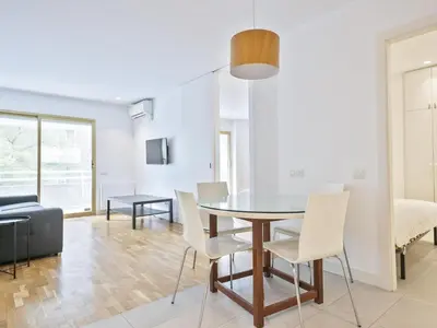 a dining room and living room with a table and chairs at Winahost Barcelona Pedralbes in Barcelona