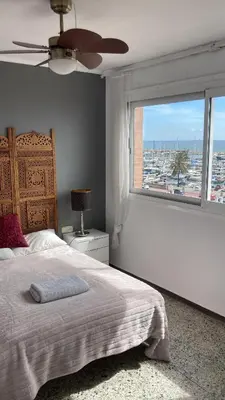 a bedroom with a bed and a large window at Masnou nice view big apartment in Masnou