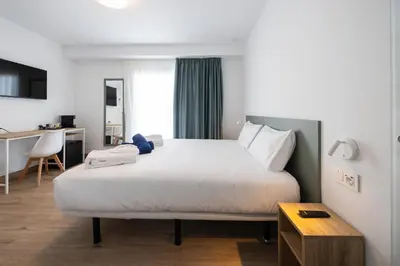 a hotel room with a bed and a desk at Hotel Calella by Beatriz Hoteles in Calella