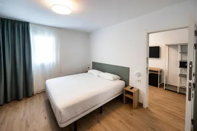 a bedroom with a white bed and a mirror at Hotel Calella by Beatriz Hoteles in Calella