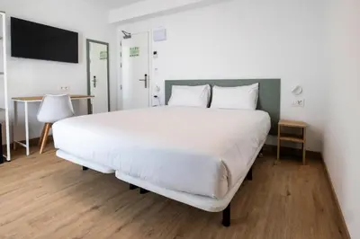 a large white bed in a room with a desk at Hotel Calella by Beatriz Hoteles in Calella