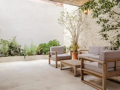 a patio with chairs and tables and plants at Luxury 2 Story Apartment Near Passeig de Gracia in Barcelona