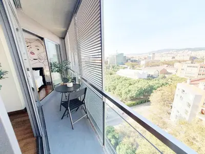a balcony with a table and a view of a city at Modern apartment in Diagonal Mar in Barcelona