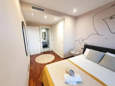a bedroom with a bed with a drawing on the wall at Modern apartment in Diagonal Mar in Barcelona